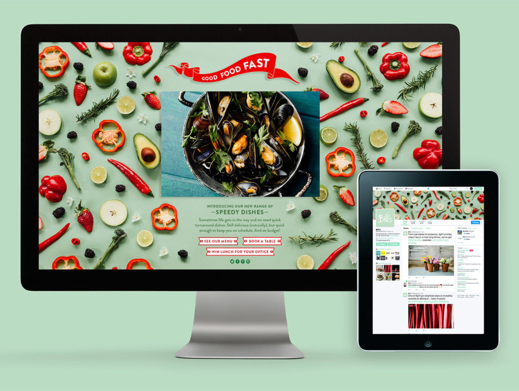 image of a desktop computer screen showing the home screen of the Bill’s restaurant including produce such as limes, broccoli, peppers and apples against a green background with a red banner and white writing saying ‘Good Food Fast’ and a picture of a bowl of mussels on a blue wooden table and links underneath it to various social media pages, and an iPad showing the Bill’s twitter account