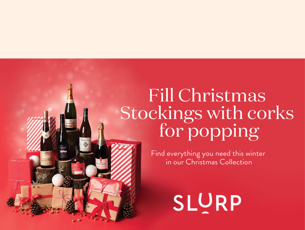 banner image showing various bottles of wine and champagne displayed with presents wrapped with red, white or brown wrapping paper with red ribbons, pinecones and gold bells against a red background with white text to the right with the headline reading ‘Fill Christmas Stockings with corks for popping’, the middle text reading ‘Find everything you need this winter in our Christmas Collection’ and the Slurp logo at the bottom